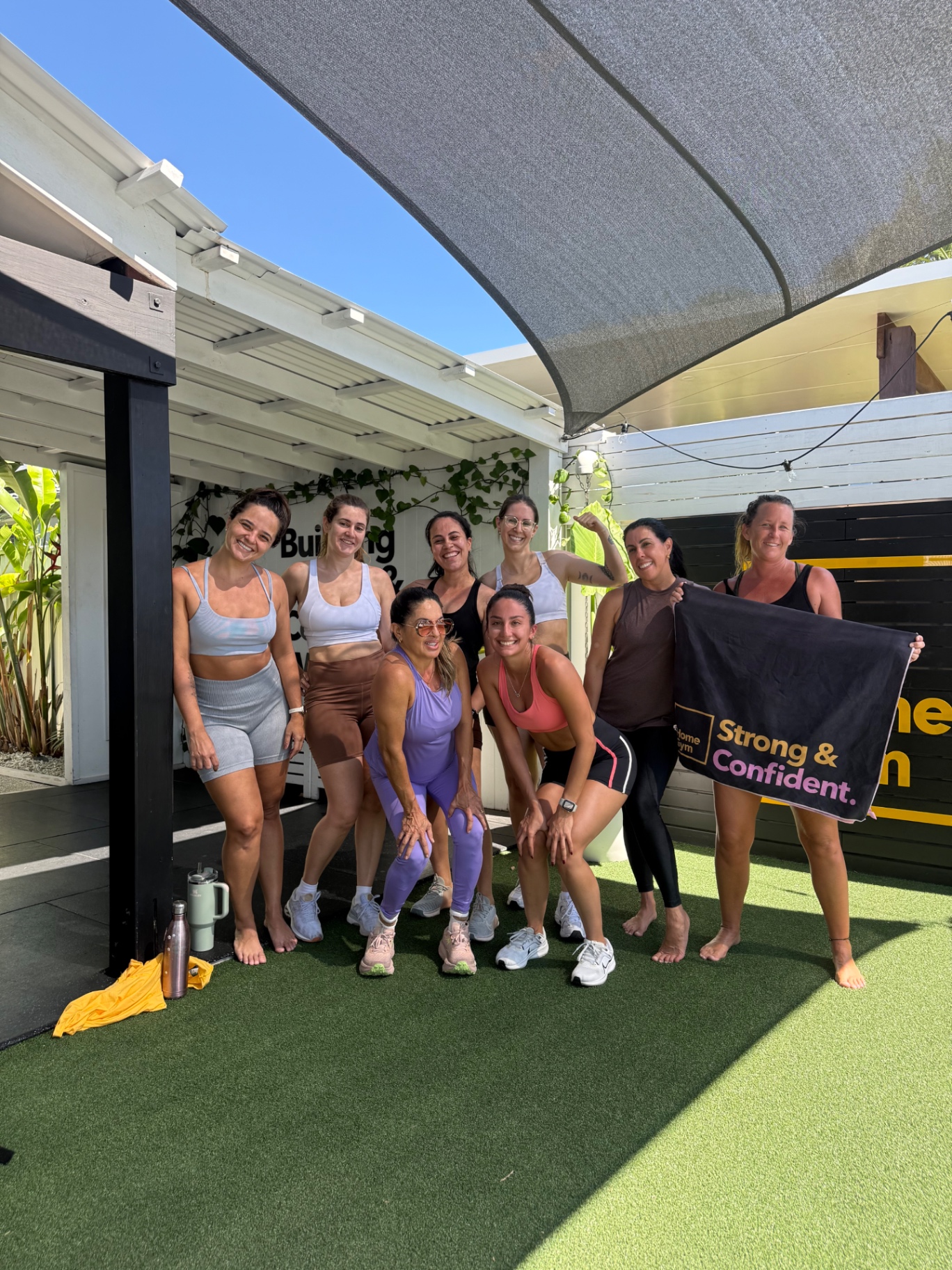 Grupo de alunas da HomeGym reunidas com a toalha Strong & Confident